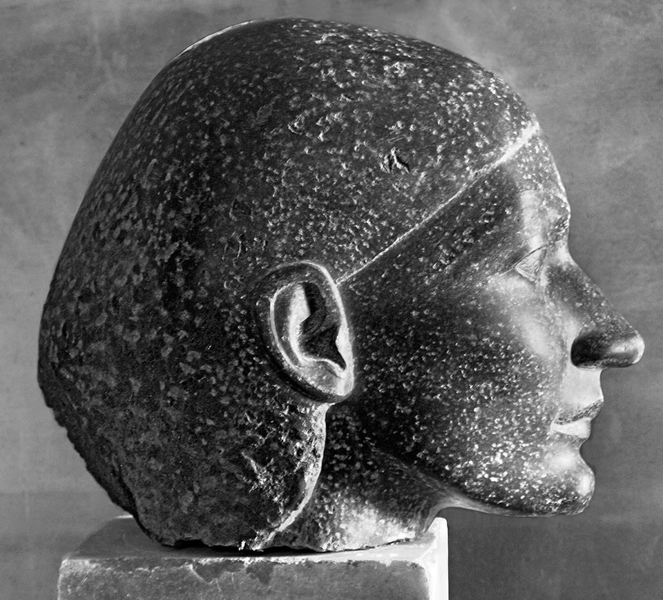 weiblicher Kopf im Profil aus dunklem Stein von Klaus Kütemeier